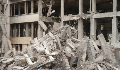 Destruction of city buildings damaged concrete structure during war. Big pile of destroyed building blocks and rubble ruined building concept