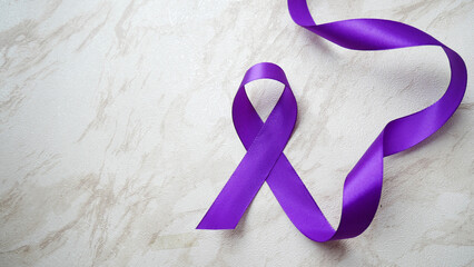 Purple ribbon with pancreatic cancer awareness on a luxury gray background.