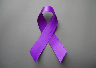 Purple ribbon with pancreatic cancer awareness on a luxury gray background.