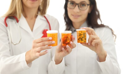 Woman doctor holding jars of medicines closeup. HIV treatment concept