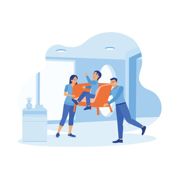 A young and cheerful husband and wife moved the armchair occupied by their son into the house. A small family moves to a new home. A couple of happy, funny parents concepts. 