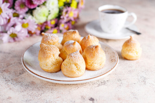 Homemade profiteroles with powdered sugar.
