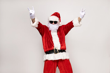 Fototapeta na wymiar A cool Santa Claus in sunglasses is dancing.
