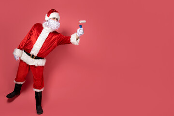 Santa Claus makes repairs on a pink background.