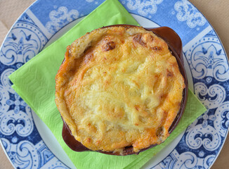 Traditional Greek style moussaka prepared and served in clay pot. Top view.