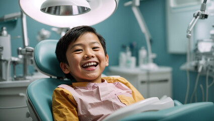 A smiling young asian boy in a dental chair. Examination by a dentist. - obrazy, fototapety, plakaty