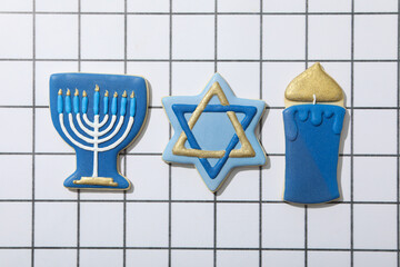 Gingerbread cookies with Jewish symbols on light background, top view