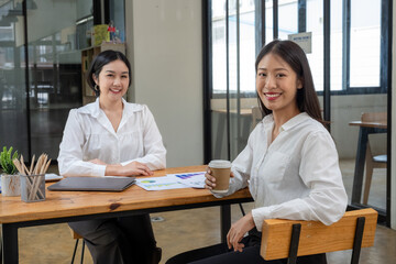 Image of two business colleagues taking a coffee break in office.