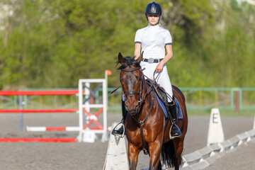 Young rider woman riding horse warming up before showjumping competition