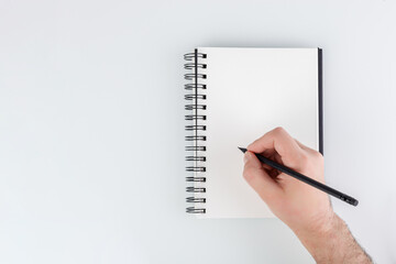 business notepad, hand holding a pencil on a white background