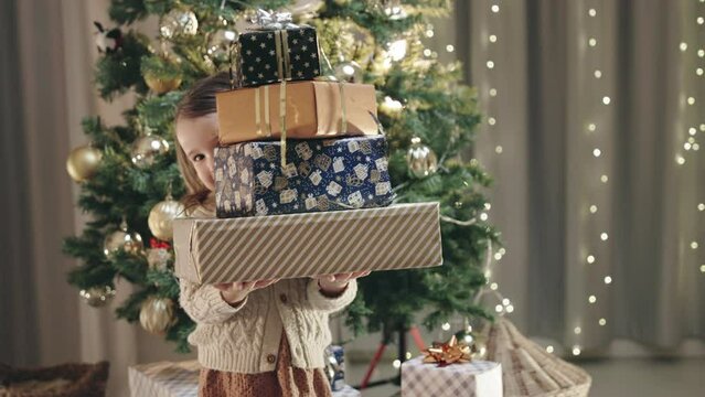 Winter Holidays Concept. A Baby Girl and Holds Several Christmas Gifts