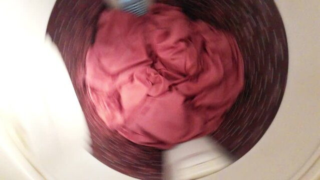 The top-loading washing machine is working in top view.