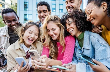 Fotobehang Group of young people using smart mobile phone outdoors - Happy friends with smartphone laughing together watching funny video on social media platform - Tech and modern life style concept © Davide Angelini