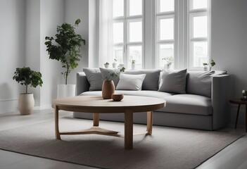 Grey sofa and round wooden table against window near white wall with frame Scandinavian home interior