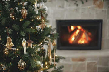 Atmospheric christmas living room with stylish tree and fireplace. Decorated christmas tree with...