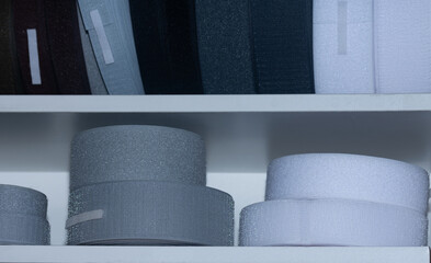 Velcro tape in rolls on a shelf, sewing and sewing accessories.