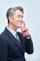  A middle-aged man in a suit is doing various facial expressions and hand movements.