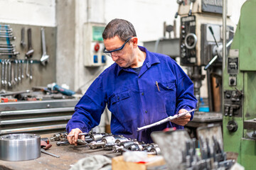Factory worker operator in the numerical control sector making a report, industrial factory