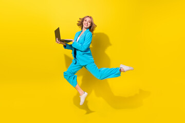 Fototapeta na wymiar Full length photo of intelligent woman wear blue stylish suit hold laptop write enjoy fast speed internet isolated on yellow background