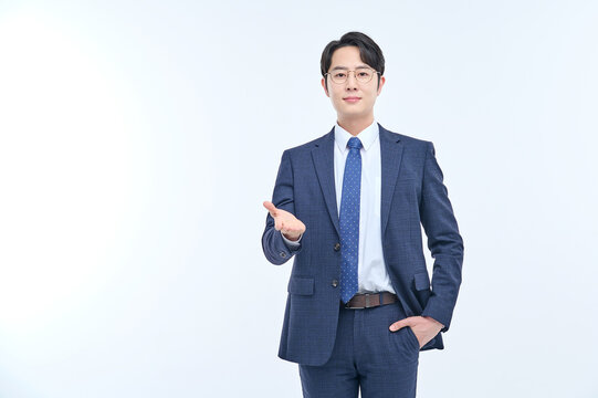 A young and handsome Asian man in a suit is wearing glasses and making various facial expressions and hand gestures.