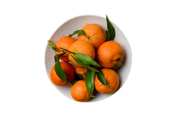 Fresh cutted clementines and whole mandarin over round plate isolated on white background. Food and...