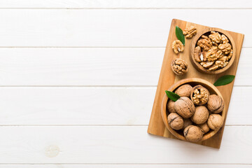 Walnut kernel halves, in a wooden bowl. Close-up, from above on colored background. Healthy eating Walnut concept. Super foods with copy space