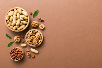 Walnut kernel halves, in a wooden bowl. Close-up, from above on colored background. Healthy eating Walnut concept. Super foods with copy space