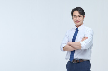 A young, handsome Asian man wearing glasses and a dress shirt and tie is holding a pen and...