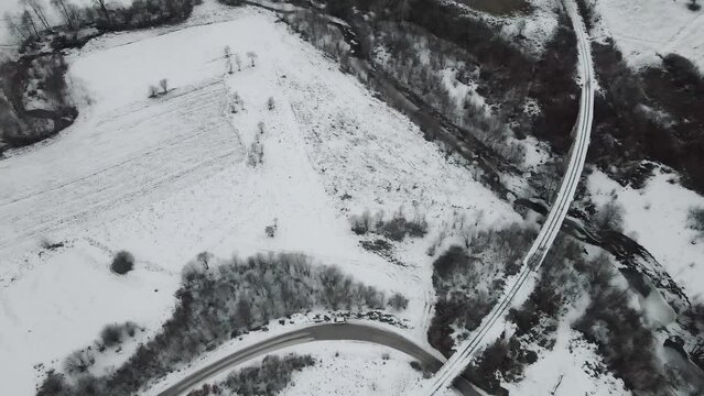 Footage of a snow covered countryside in mountion from above
