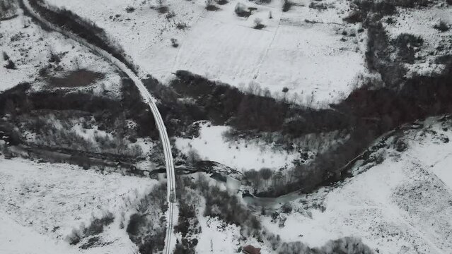 Footage of a snow covered countryside in mountion from above
