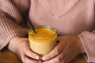 Woman in a Cosy Warm Sweater Holding a Cup of Coffee. Healthy Turmeric Autumnal Spicy Beverage....