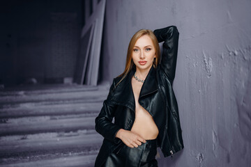 Beautiful young red-haired long-haired woman in black leather shirt
