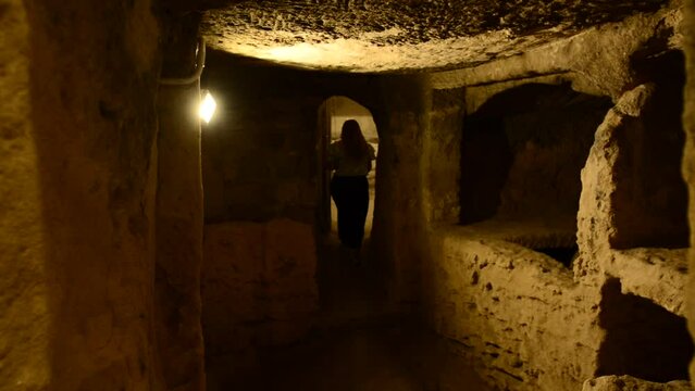 Girl explores inside dark and mysterious Catacombs of Kom El Shoqafa, Alexandria, Egypt