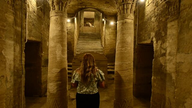Girl explores mysterious catacombs of Kom El Shoqafa in Alexandria Egypt. Mystery