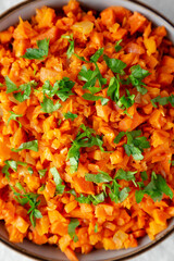 Homemade Smoky Spiced Carrot Rice with Parsley in a Bowl, top view.