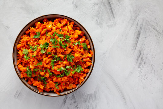 Homemade Smoky Spiced Carrot Rice with Parsley in a Bowl, top view. Flat lay, overhead, from above. Copy space.