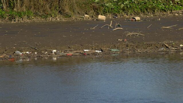 Garbage and plastic waste in the river bed - (4K)