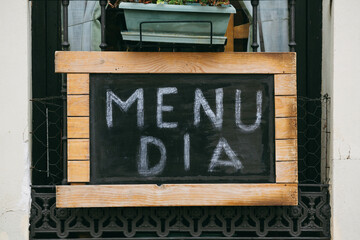 Close-up of a sign on the façade of a Spanish restaurant. Translation of the inscription: "Business lunch."