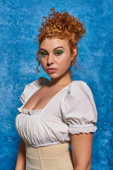 headshot of attractive redhead plus size woman in white elegant blouse on white textured backdrop