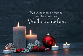 Weihnachtskarte: Brennende Kerzen und Weihnachtsdekoration mit dem Text wir wünschen ein...