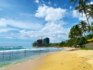 Obraz premium View of a beautiful sandy beach with palm trees, Indian Ocean coast in Sri Lanka, Unawatuna