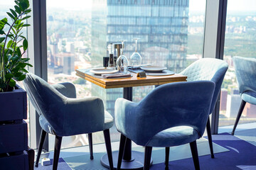 The interior of a restaurant on the top floors of a skyscraper. View overlooking the town.