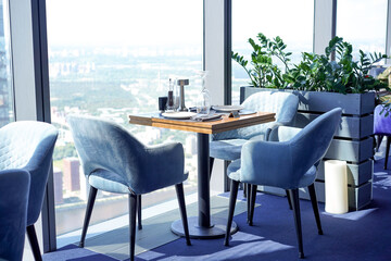 The interior of a restaurant on the top floors of a skyscraper. View overlooking the town.