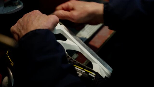 Skate sharpening. Men's hands work metal on skates.
