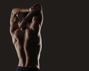 Fototapeta na wymiar Attractive muscular sensual man posing back view