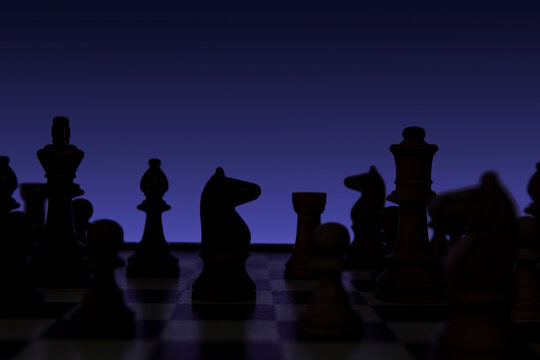 Knight in a chess duel on the chessboard. Low-key concept picture of chess pieces taken in studio and concerning decision making and strategy.