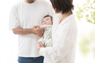 happy family face of a father and mother holding a baby in a bright white room Images of infertility treatment, older childbirth, etc.