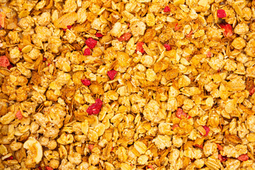 Top view pile of delicious breakfast crunchy muesli with strawberry and raspberry.