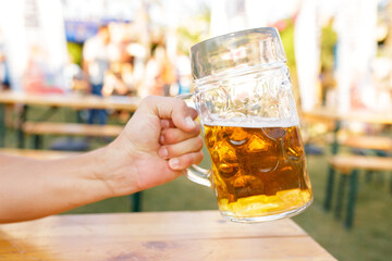 Hand holding a mug of beer toasting. Octoberfest