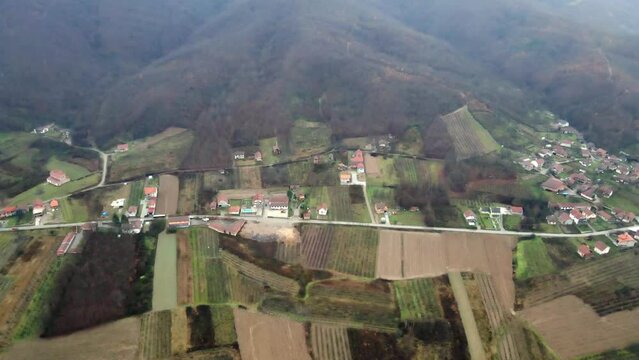 Aerial view of agricultural fields in town Leskovac in Serbia in cold foggy day with mountain in the background